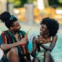Young couple enjoying colorful drinks by the pool